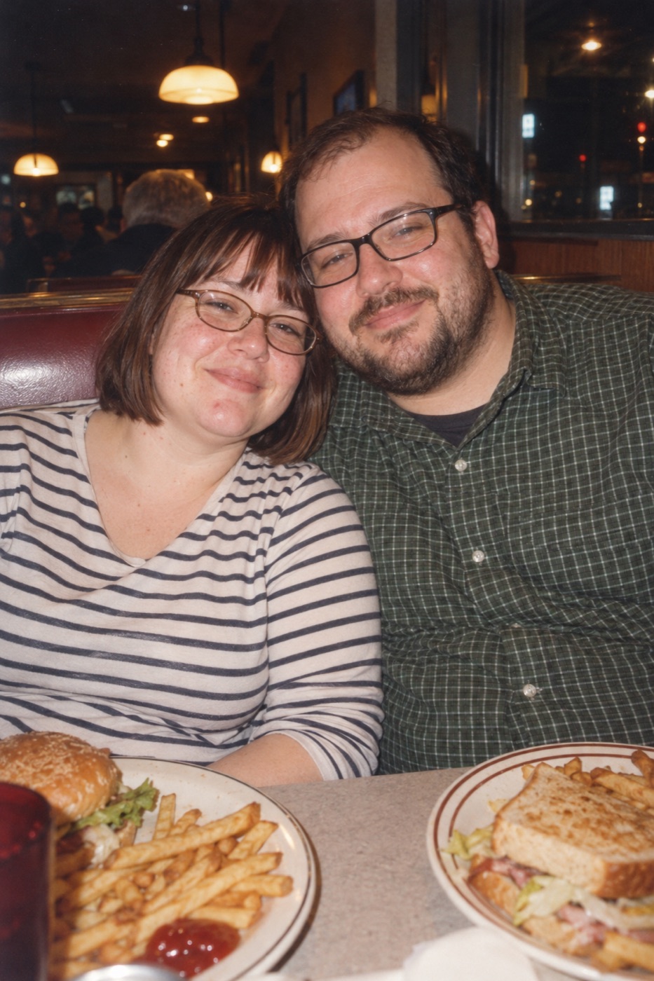 Martina e Ignacio en un diner, con hamburguesa y papas fritas